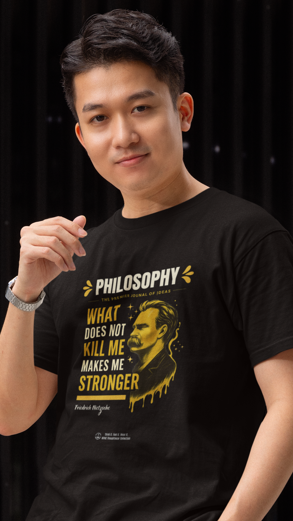 Zwarte T-shirt met citaat van Friedrich Nietzsche: ‘What does not kill me makes me stronger’, in gele en witte letters met portretillustratie