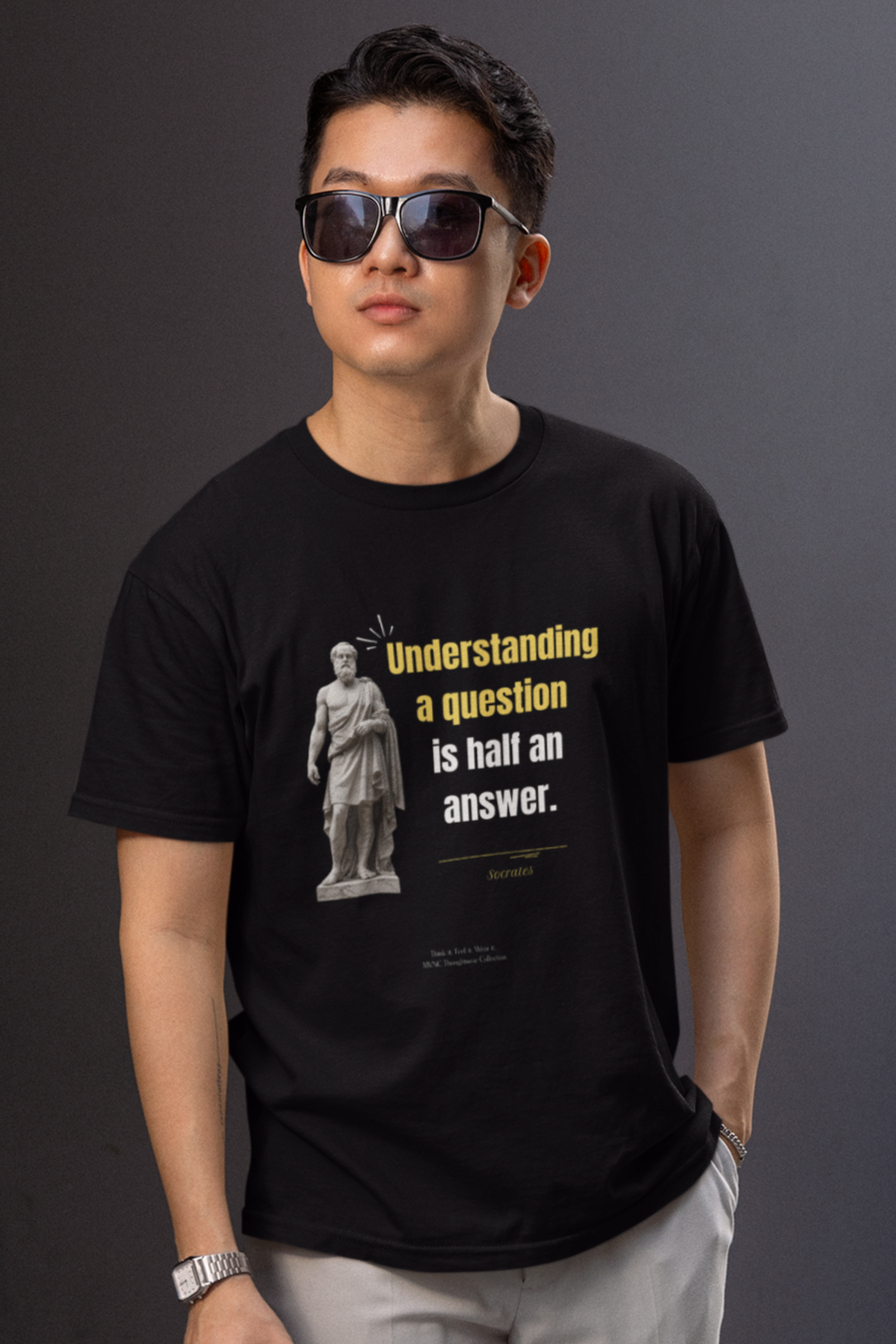 Zwarte T-shirt met citaat van Socrates: ‘Understanding a question is half an answer’, met gele en witte letters en een beeldhouwwerk van Socrates