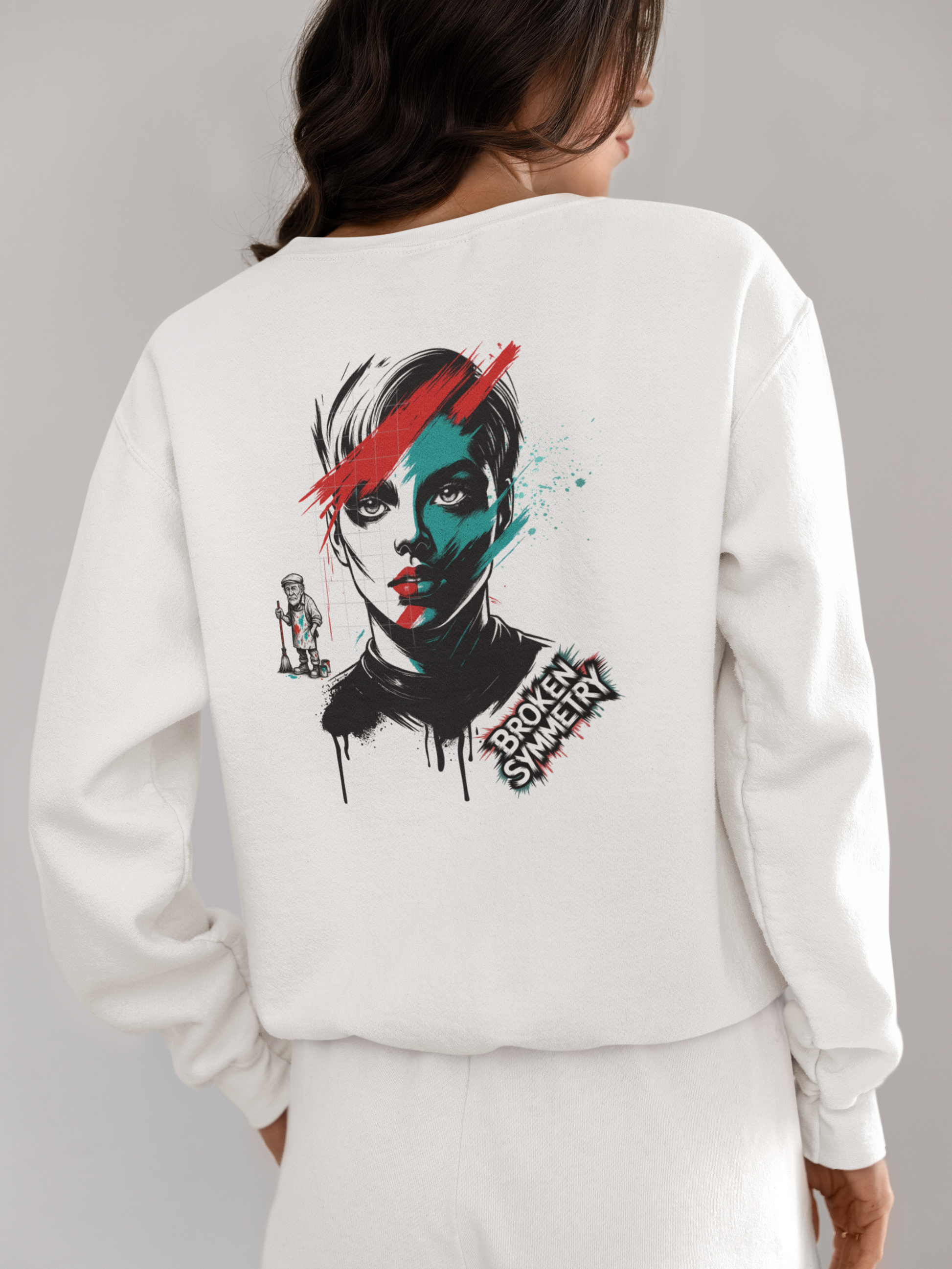 Achteraanzicht van een vrouw die een witte sweatshirt draagt met een kleurrijk urban kunstportret en de tekst "Broken Symmetry".